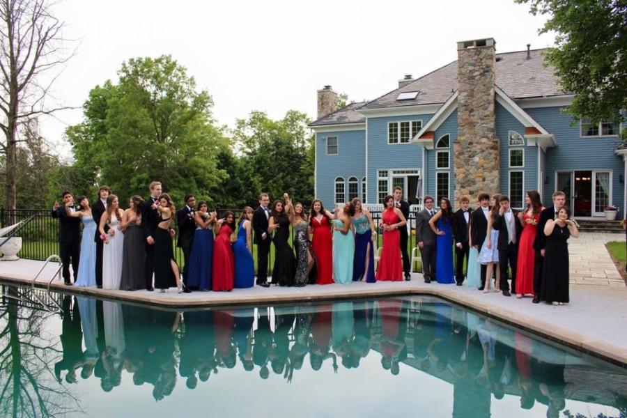 A group poses around a beautiful swimming pool. 