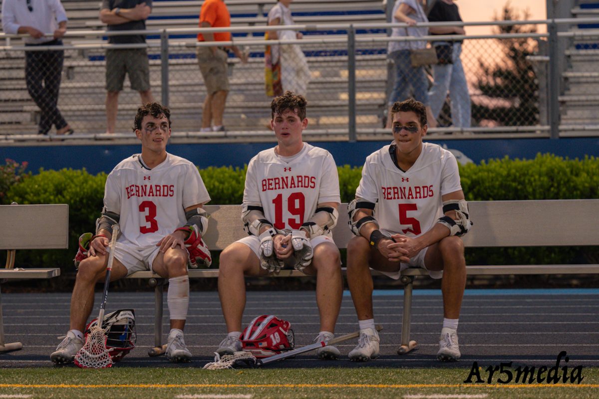 Seniors Jake Caldwell, Charlie Vaccaro, and Trevor Sardis sitting together one last time on the lacrosse field.