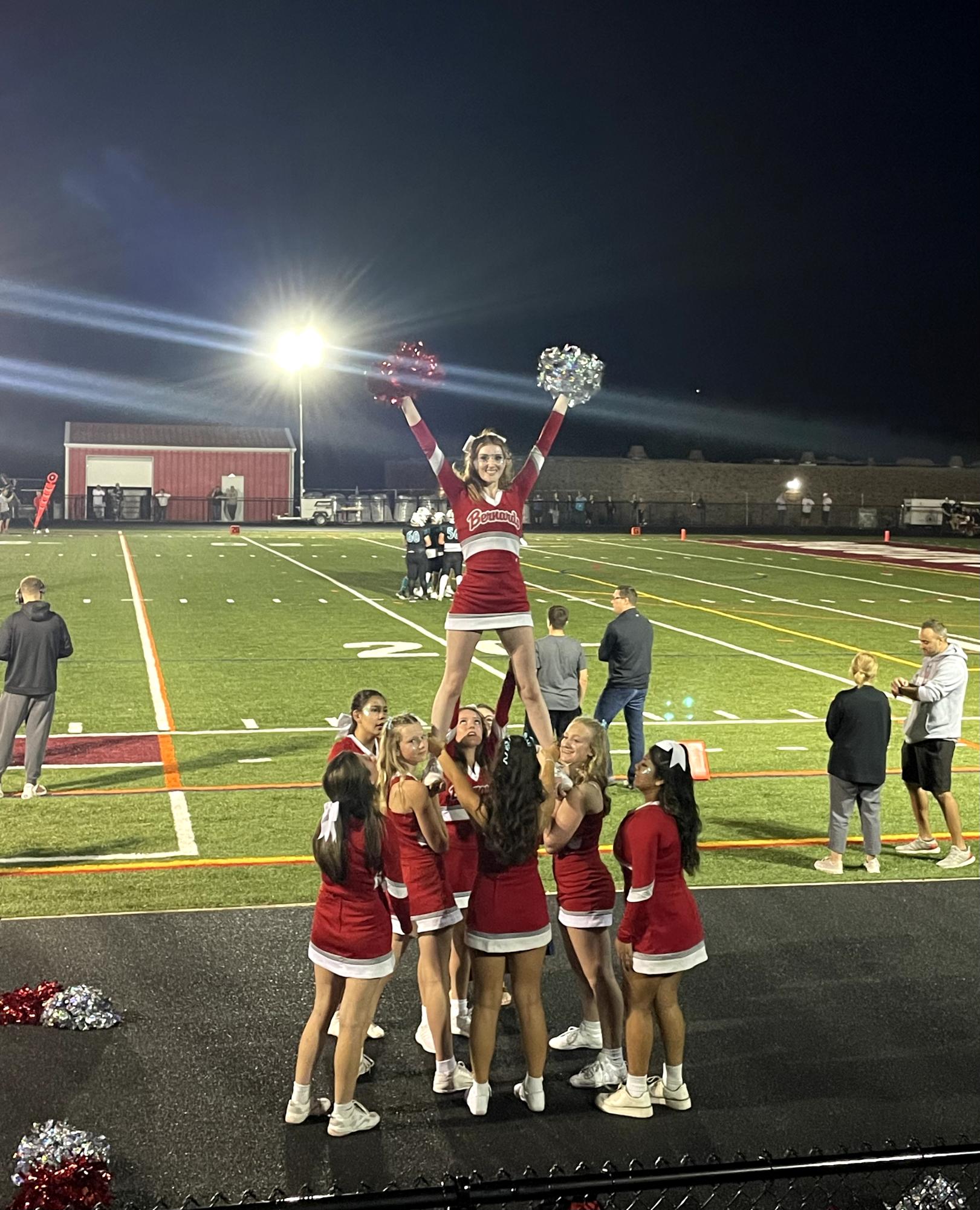 The cheerleading team integrates new stunts into their performances to increase audience engagement. 