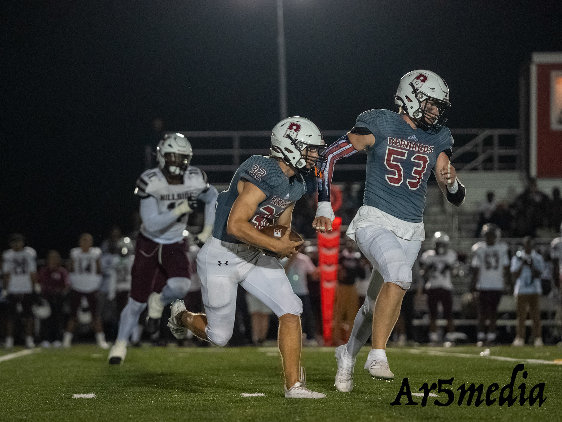 Junior Logan Stevens running behind Grayson Meyer looking to cut up field.