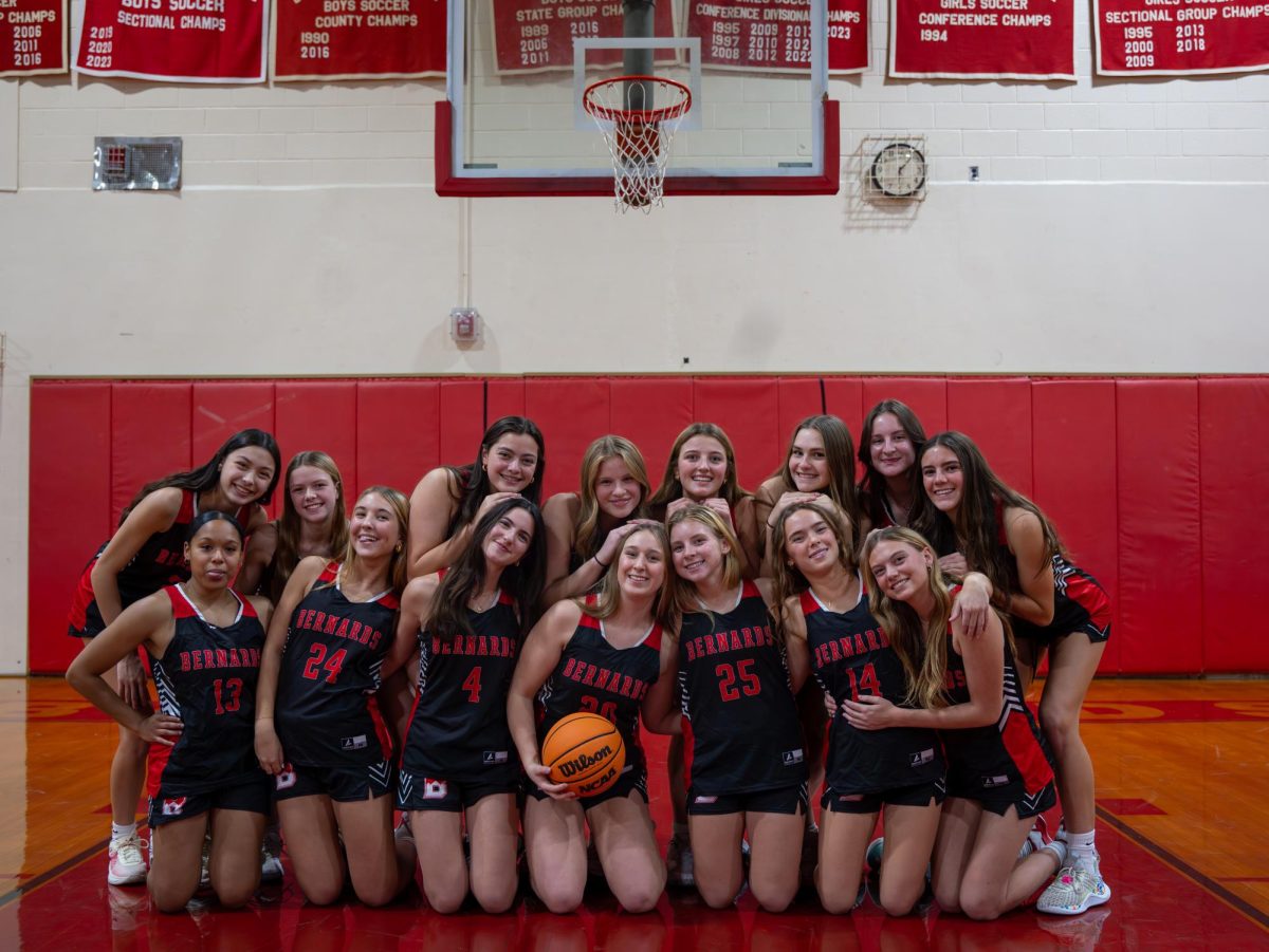 The Girl's Basketball Team pose for a photo on their home court. 