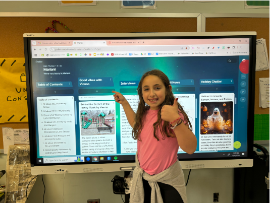 Vienna Caruso, a fourth grade student at Bedwell Elementary School, poses in front of her column of her articles.