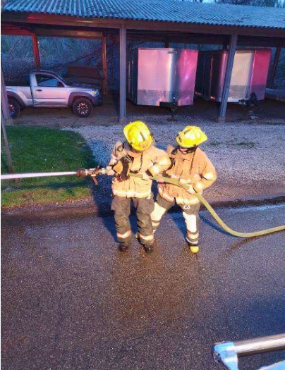 Kilian (left) works with a fire hose alongside Grayson 